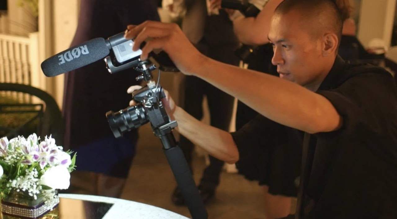 Tommy Khounlivong filming during a wedding reception